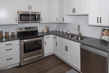 a kitchen with white cabinets and stainless steel appliances